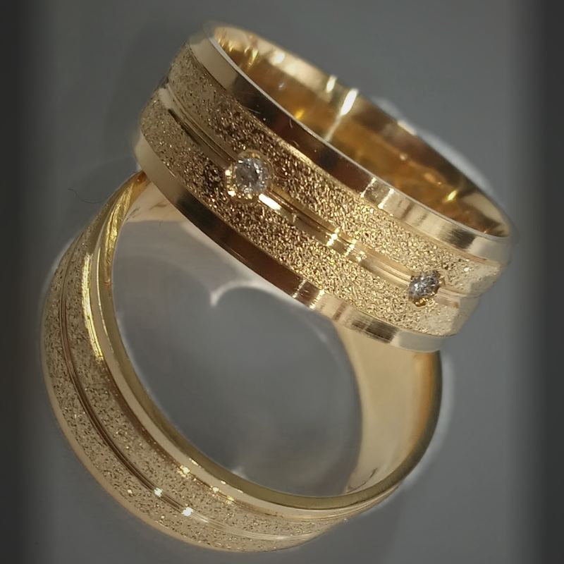 Alianças em ouro com faixa diamantada fosca, friso polido e duas pedras