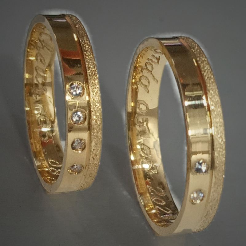 Alianças personalizadas em ouro com pedras, faixa fosca e frase gravada por dentro