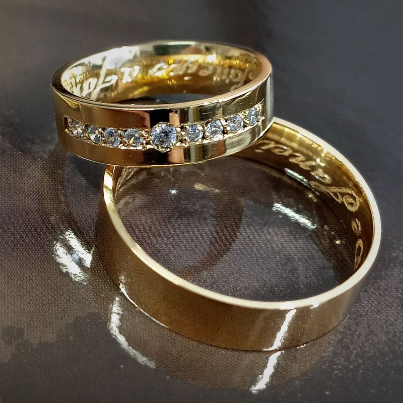 Alianças personalizadas em ouro polido com fileira de pedras e frase gravada por dentro